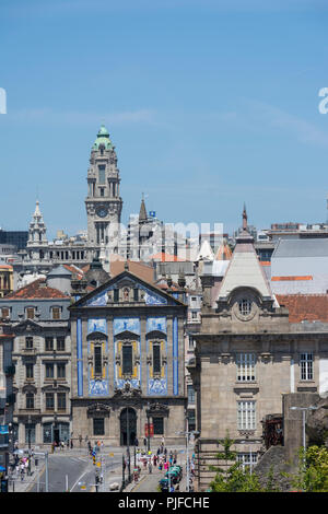 PORTO, PORTUGAL - JULY 21, 2017: At foreground, San Bento railway station, the church of Congregados. At background, clock tower of town hall building Stock Photo