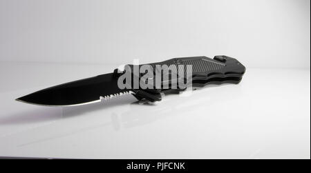 Survival knife black ops military weapon isolated on white with serrated blade. Stock Photo
