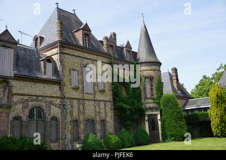 Green ivy growing wild on the facade of a small old stone country estate in the country in France Stock Photo