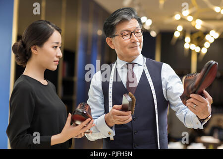 Fashion designers polishing leather shoes Stock Photo