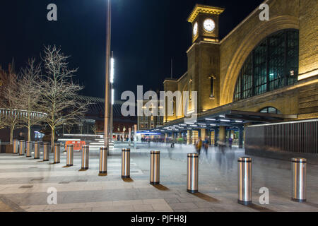 London, England, UK - February 27, 2018: Crowds of pedestrians walk through a plaza outside King's Cross railway terminus and tube station in London a Stock Photo