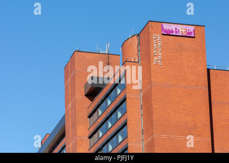 Manchester, England, UK - June 30, 2018: The logo of the University of Manchester is lit up by evening sunlight on a campus building. Stock Photo