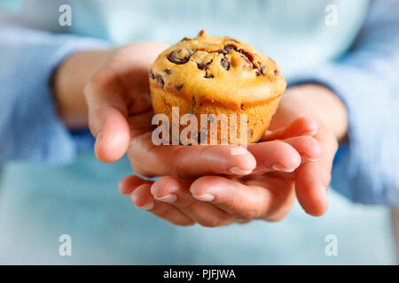 Pastry: muffins with chocolate sprinkles. Woman holding muffins in her hands Stock Photo