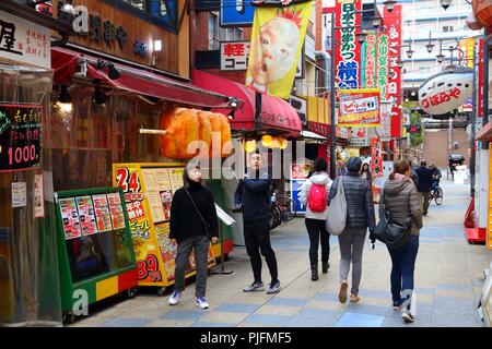 OSAKA, JAPAN - NOVEMBER 23, 2016: People visit Shinsekai neighborhood of Osaka, Japan. Osaka belongs to 2nd largest metropolitan area of Japan (19.3 m Stock Photo