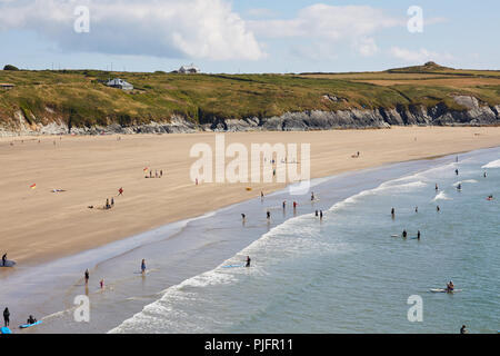 High viewpoint of people learning to surf in the sea at Whitesands Bay in Pembrokeshire Wales on the south coast on a sunny blue sky day Stock Photo