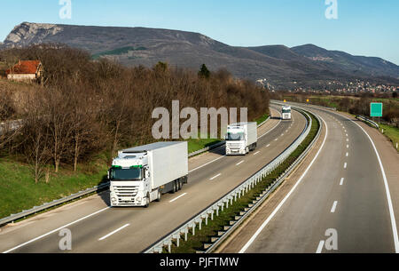 Fleet or convoy of trucks in line on a country highway Stock Photo