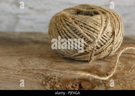 ball of twine on a natural wooden background Stock Photo