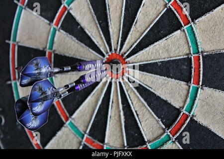 dart board with three darts in the bullseye closeup Stock Photo
