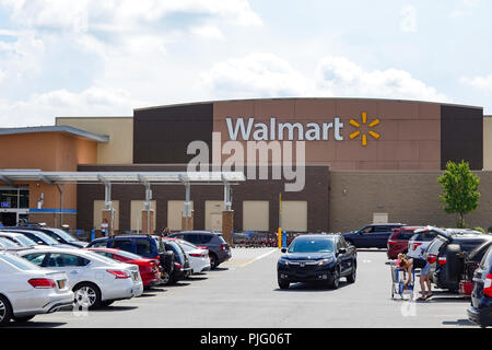 A Walmart Supercentre in Gloversville, NY USA with a parking lot full of vehicles and people. Stock Photo