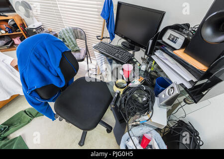 Messy, cluttered teenage boys bedroom desk and work area. Stock Photo