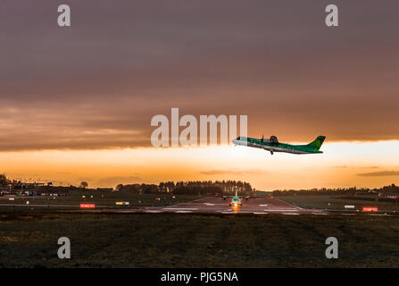 Cork, Ireland, 4th April 2017 The dawn flight of an Aer Lingus regional aircraft  as it departs for Edinburgh, while the Manchester flight waits for i Stock Photo