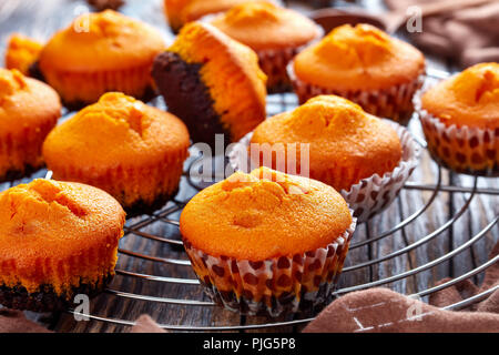 close-up of freshly baked homemade sweet pumpkin muffins  on a Round Stainless Steel Cake Cooling Rack on a rustic wooden table, delicious autumn dess Stock Photo