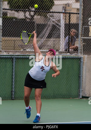 High school varsity tennis player from Foothill Tech reaching her racket up for the serve during her match against St Bonaventure on September 4, 2018 Stock Photo