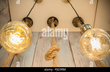 Rope light bulbs over weathered wooden background. Low angle view Stock Photo
