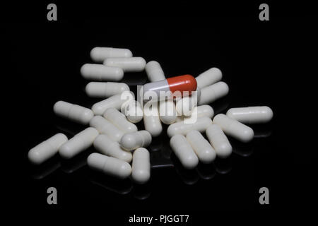 Close up of pills and medicine capsules on a black surface. Old age medications for various diseases to maintain health. Stock Photo