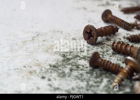Close up selective focus of rusty screws. old steel bolts on grungy white wood background Stock Photo