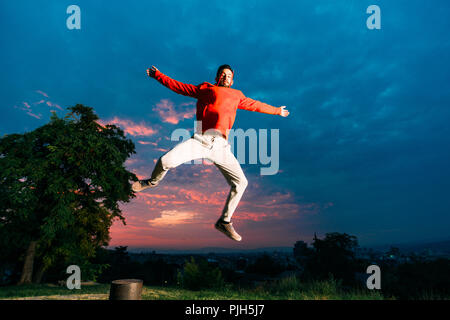Young man practicing parkour while jumping in park Stock Photo