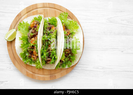 Shrimp tacos on round bamboo board on white wooden background, top view. Mexican food. Flat lay, overhead, from above. Copy space. Stock Photo