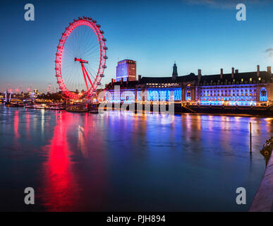 London Eye and County Hall, on the South Bank of the Thames, illuminated at twilight. Stock Photo