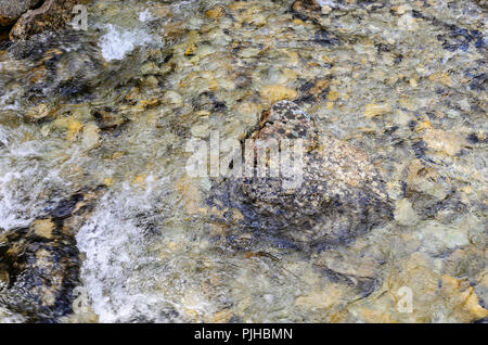 Mountain river. The texture of the rocky bottom is visible. Stock Photo