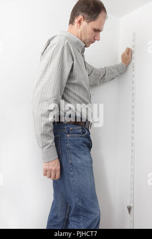 Man determining the vertical directions using plumb bob whileout assembling the closet Stock Photo