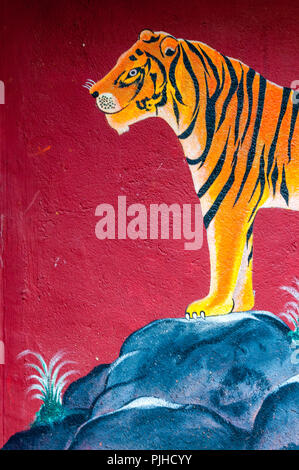 MUMBAI, INDIA – August 9 2018: Mural of a tiger  on a Warli temple surrounded by trees. Warli are indigenous tribal people known for their art. They r Stock Photo