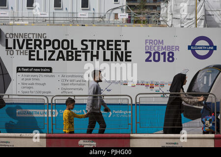 Londoners and commuters walk past the billboards promoting Crossrail's new Queen Elizabeth rail line, the capital's newest  on 3rd September 2018, on Moorgate in London, England. Crossrail's Elizabeth Line is a 118-kilometre (73-mile) railway line under development in London and the home counties of Berkshire, Buckinghamshire and Essex, England. Crossrail is the biggest construction project in Europe and is one of the largest single infrastructure investments ever undertaken in the UK - a£15bn transport project that was due to open in December 2018 but now delayed to autumn 2019. Stock Photo