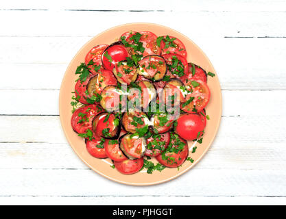 fried eggplant with tomatoes, garlic and mayonnaise on a white wooden background, top view close-up Stock Photo