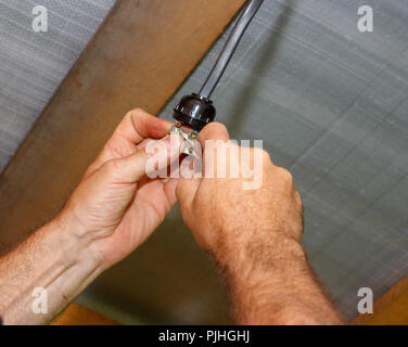 man electrician installs an electric lamp holder Stock Photo