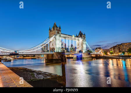 The Tower Bridge in London at night with the City in the back