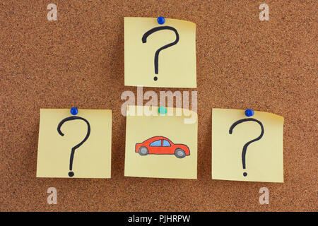 Car Questions. Notes with car and question marks on bulletin board. Close up. Stock Photo