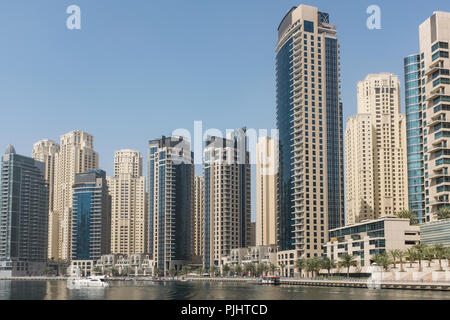 Skyscrapers in Dubai Marina, with the sand-coloured residential towers of Jumeirah Beach Residence in the background, in Dubai, United Arab Emirates.  Stock Photo