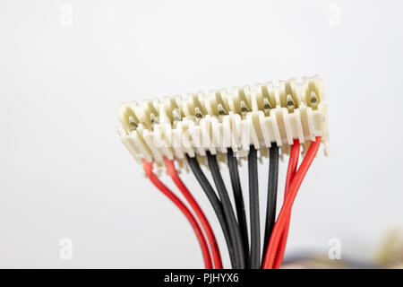 Old cables for electrical devices on a white table. Electrical connectors from household appliances. White background. Stock Photo