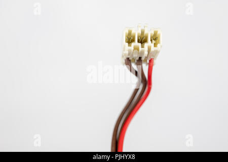 Old cables for electrical devices on a white table. Electrical connectors from household appliances. White background. Stock Photo