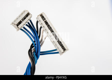 Old cables for electrical devices on a white table. Electrical connectors from household appliances. White background. Stock Photo