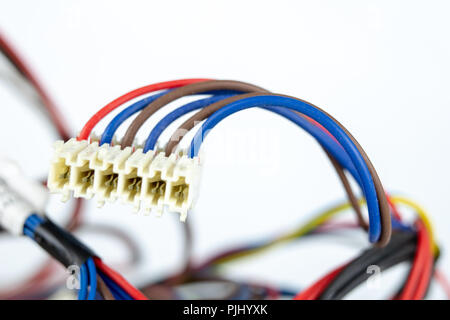 Old cables for electrical devices on a white table. Electrical connectors from household appliances. White background. Stock Photo