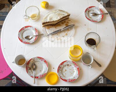 Dirty dishes and half of the homemade cake on the table Stock Photo