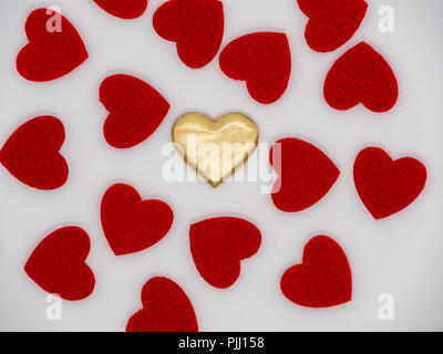 Single golden heart in the middle of red hearts Stock Photo