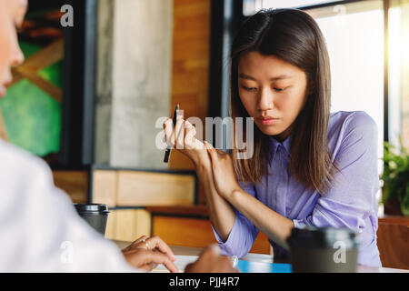 Two colleagues discussing in cafe, sitting at table Stock Photo