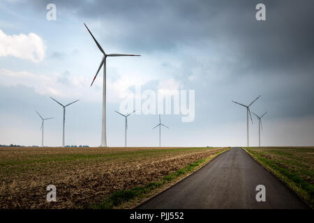 Street towards windmills with cloudy weather. Stock Photo