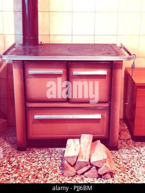 old wood stove in a kitchenette with 70s antiqued effect Stock Photo