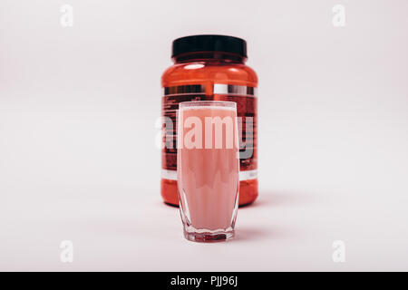 Can of protein and ready-made sports drink in glass on white background. Additional nutrition for muscle building. Stock Photo
