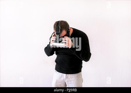 Man using a virtual glasses on white background. Young male business executive using virtual reality headset in office. Stock Photo