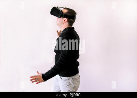 Man using a virtual glasses on white background. Young male business executive using virtual reality headset in office. Stock Photo