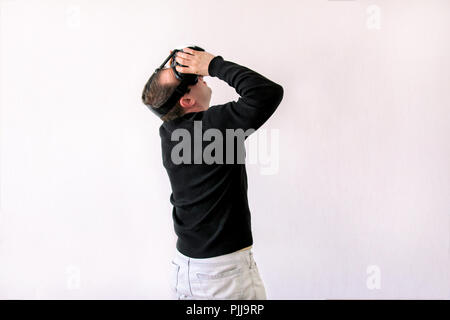 Man using a virtual glasses on white background. Young male business executive using virtual reality headset in office. Stock Photo