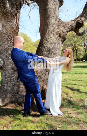 Wedding. Happy wedding couple in the forest. Happy married couple is standing and hands wide open. A wedding couple who stay and enjoy in the natural. Stock Photo