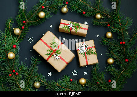 Christmas handmade gift boxes decorated with craft paper and white snowflakes on dark background top view. Merry christmas greeting card. Happy New Year. Stock Photo