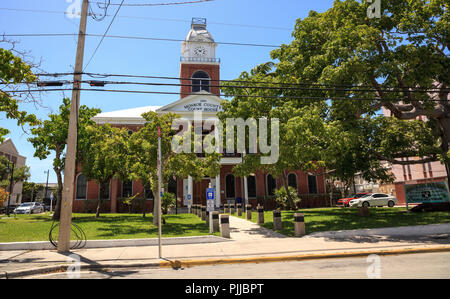 Key West, Florida, USA - September 1, 2018: Monroe County Courthouse with a Large Kapok tree Ceiba pentandra, also called the Ceiba tree, growing in f Stock Photo