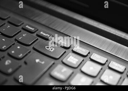 Slanted view of a black computer keyboard. Focusing and giving importance to the Delete button on the keyboard. Stock Photo