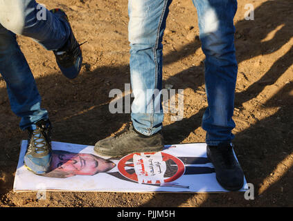 Gaza, Palestine. 7th Sep, 2018. Two Palestinians seen stepping on a poster with US President Donald Trump during the clashes.Clashes between the Israeli forces and Palestinian citizens during a protest against the decision of President Trump to recognizing Jerusalem as the capital of Israel. The protest was entitled: Return despite your nose Trump. Credit: Ahmad Hasaballah/SOPA Images/ZUMA Wire/Alamy Live News Stock Photo